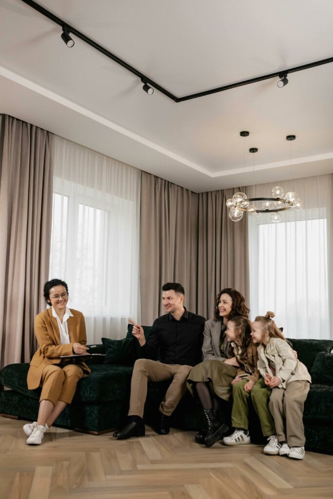 Understanding the New Child Investment Accounts for 2025–2028 Births 3 family discusses new home purchase with real estate agent in a cozy living room setting.